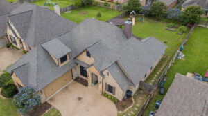 Overhead view of a home with a new roof replacement with malarkey highlander shingles in a color of weathered wood - College station Roofing companies Sustainable Roofing LLC