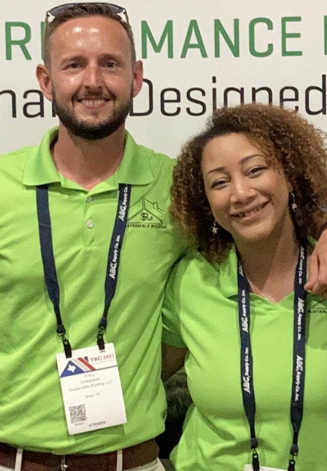 Husband and wife co-owners smiling wearing neon green polo shirts - Sustainable Roofing LLC